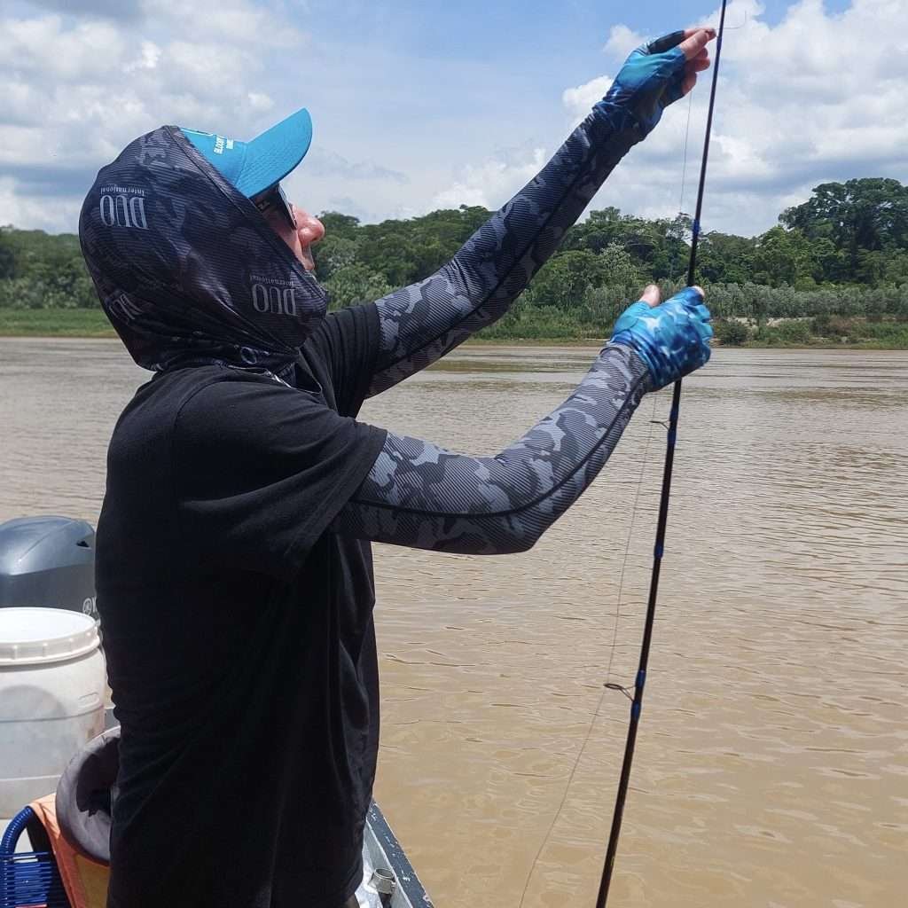 Kieran rigging a rod to go fishing in Tambopata Peru
