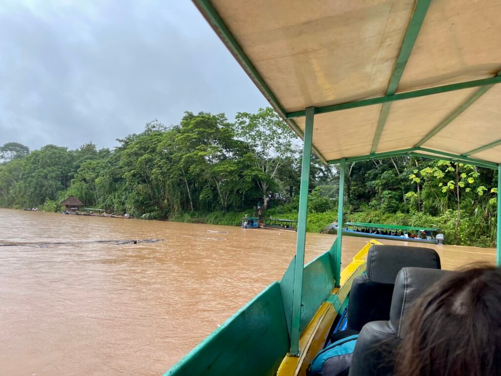 Several motorized boats congested at a riverbank unloading point in the Peruvian Amazon.