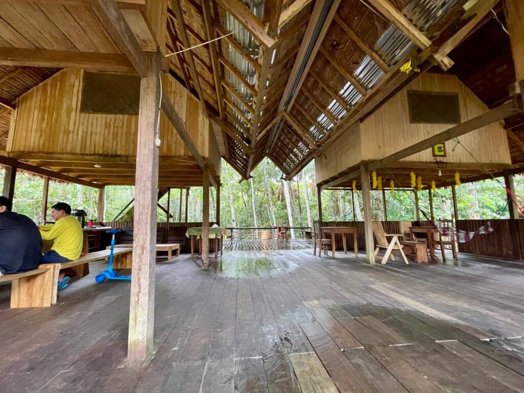 The simple wooden communal social and dining area of a budget-friendly Amazon jungle lodge.