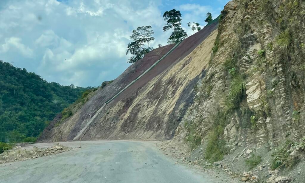 Scarred mountain slope above the 30C Interoceanic Highway, showing the unstable terrain of the cloud forest sections.