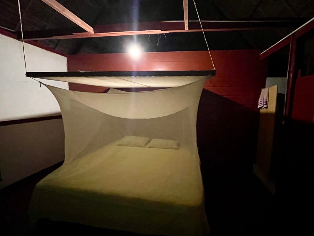 A rustic room with a basic mosquito net in a high-priced Amazon lodge, showing the unvarnished reality of jungle luxury.