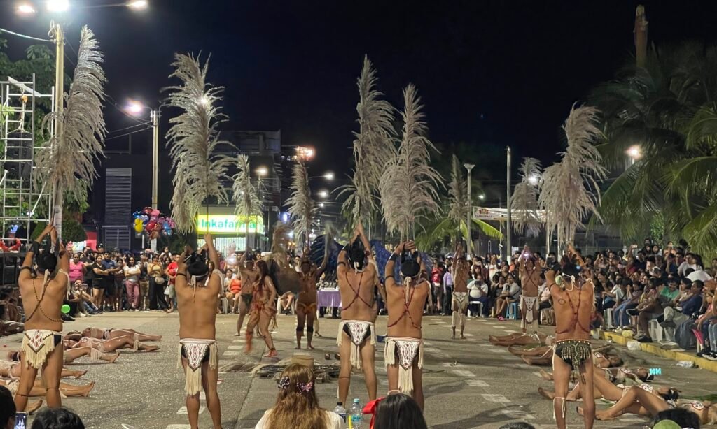 Traditional dancers performing in the streets of Puerto Maldonado during a local festival at night.