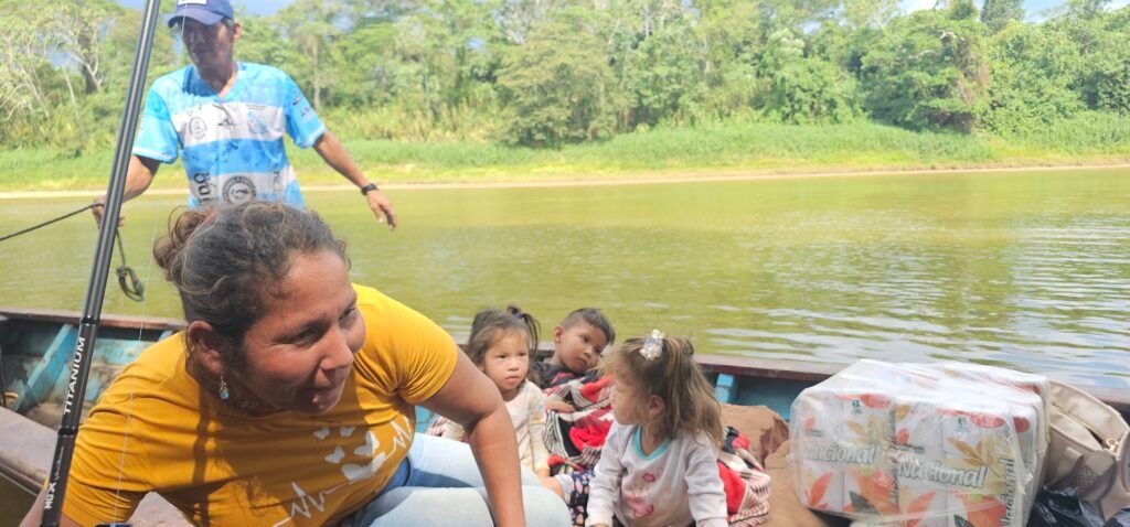 Local family traveling by motorboat on the Madre de Dios River, showcasing the daily reality of river transport in the Peruvian Amazon.