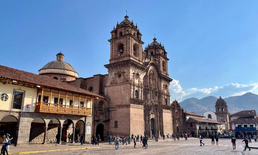 View from the steps of the Cusco Cathedral looking across the Plaza de Armas toward the Templo de la Compañía de Jesús.