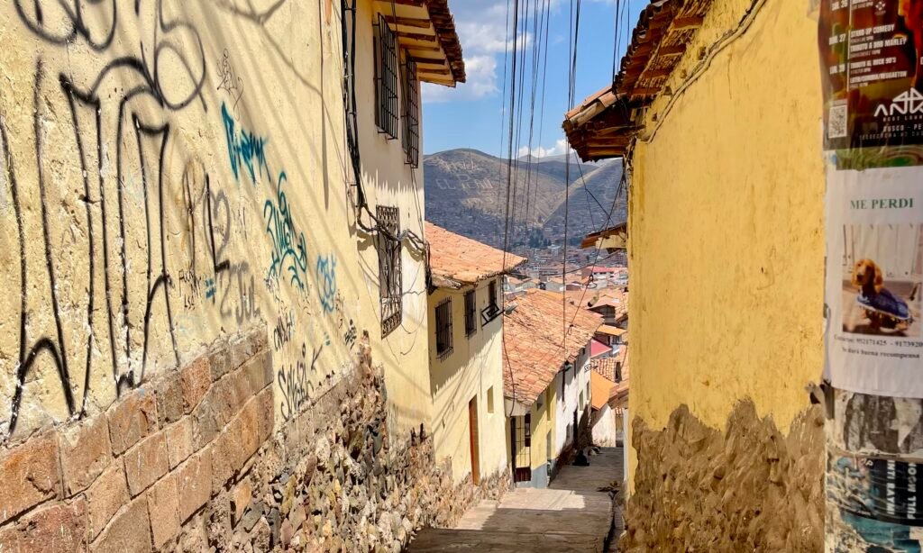 Looking through a narrow, steep cobblestone passage in Cusco that leads down from the city's hillside neighborhoods.