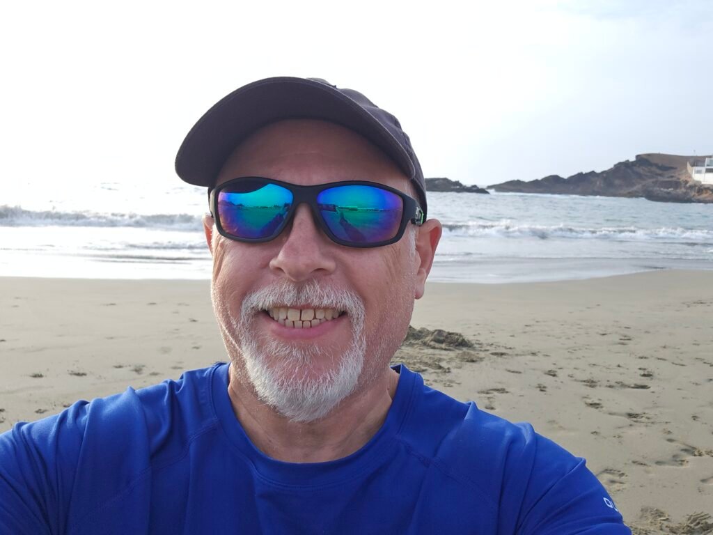 A traveler, Dave from Canada, taking a selfie on a beach in Huarmey with the ocean in the background.