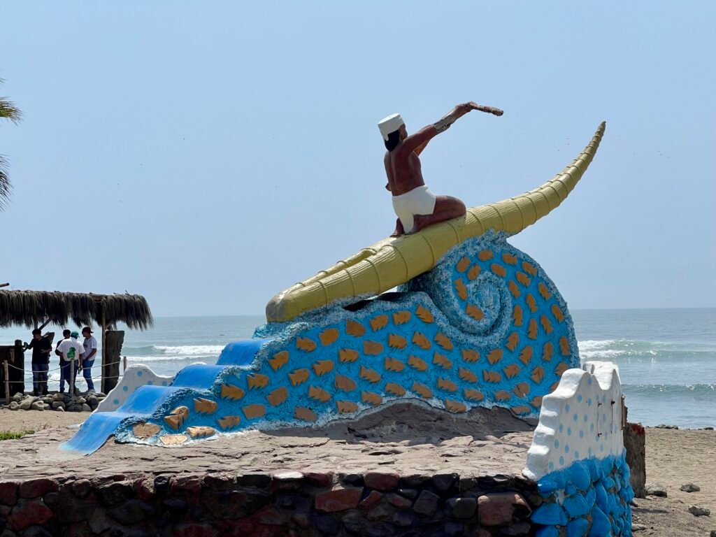Monument in Huanchaco depicting a fisherman riding a traditional caballito de totora reed craft on a wave.