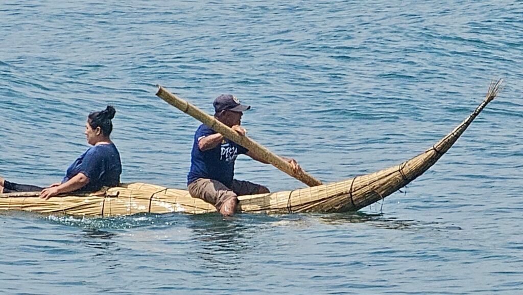 A local fisherman navigating the Pacific ocean in a traditional reed boat, or caballito de totora, off the coast of Huanchaco.
