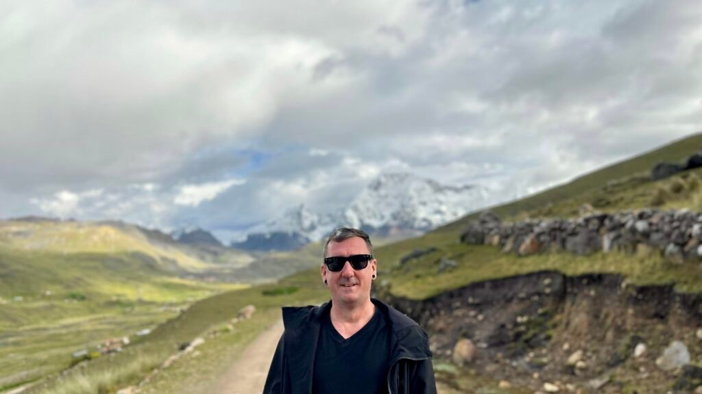 Kieran Proctor, founder of In Lovely Blue, standing in the Peruvian Andes, drawing on decades of first-hand travel experience to help you plan your trip.