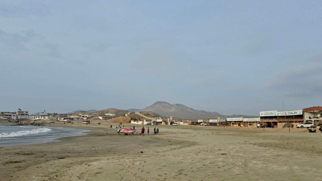 A view of Playa Tuquillo's coastline with mountains in the background, a popular stop on the overland route from Lima to Trujillo.