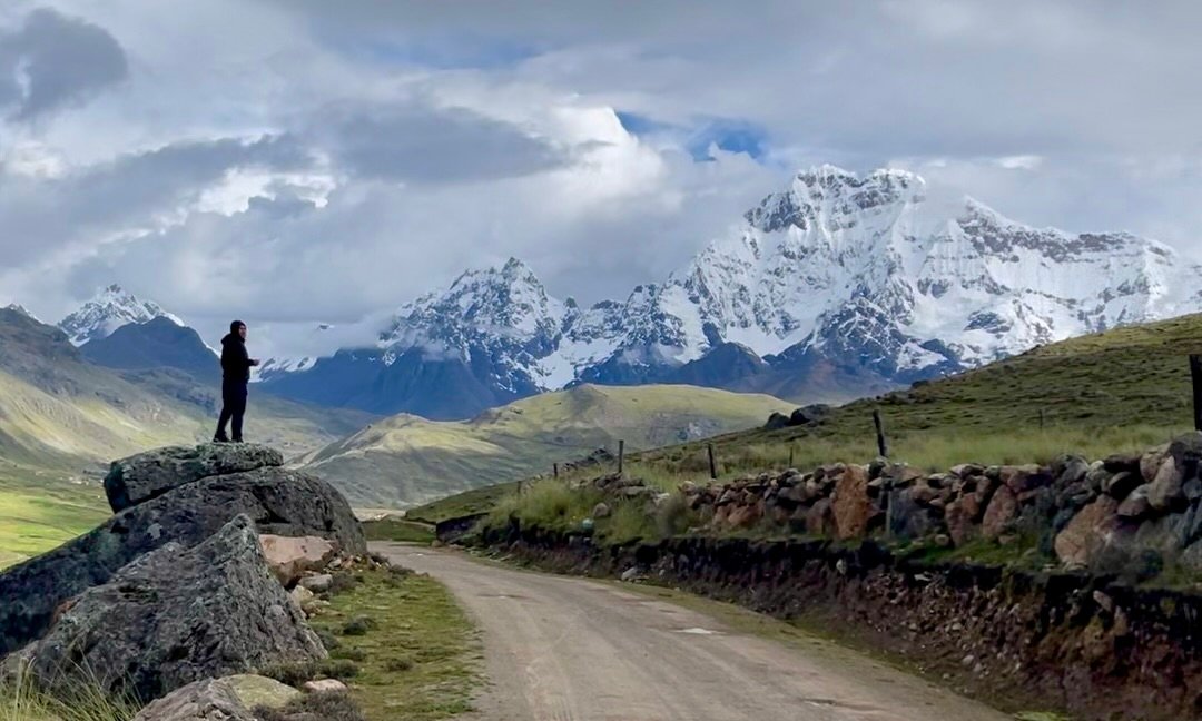 Panoramic view of the snow-capped Ausangate mountain range in the Peruvian Andes, illustrating the extreme altitude and vertical scale of the landscape.