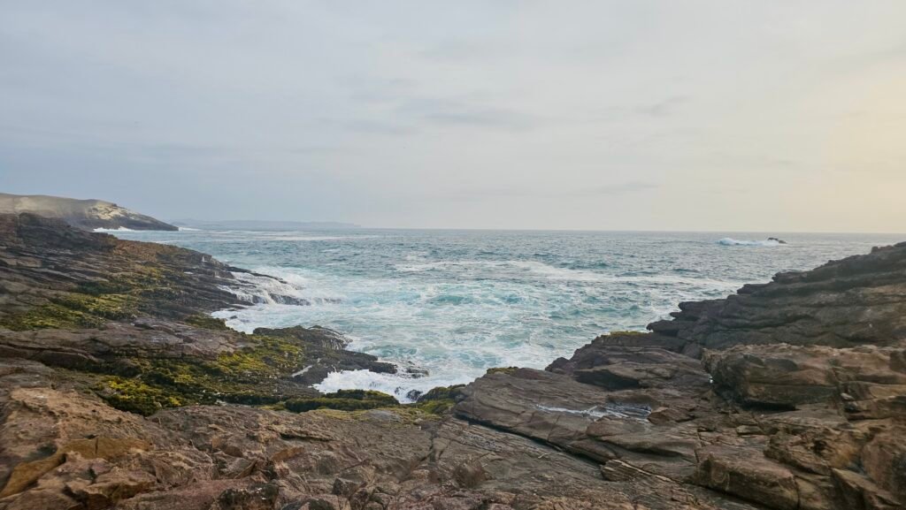 Waves crashing against the rocky and arid coastline near Huarmey, Peru.